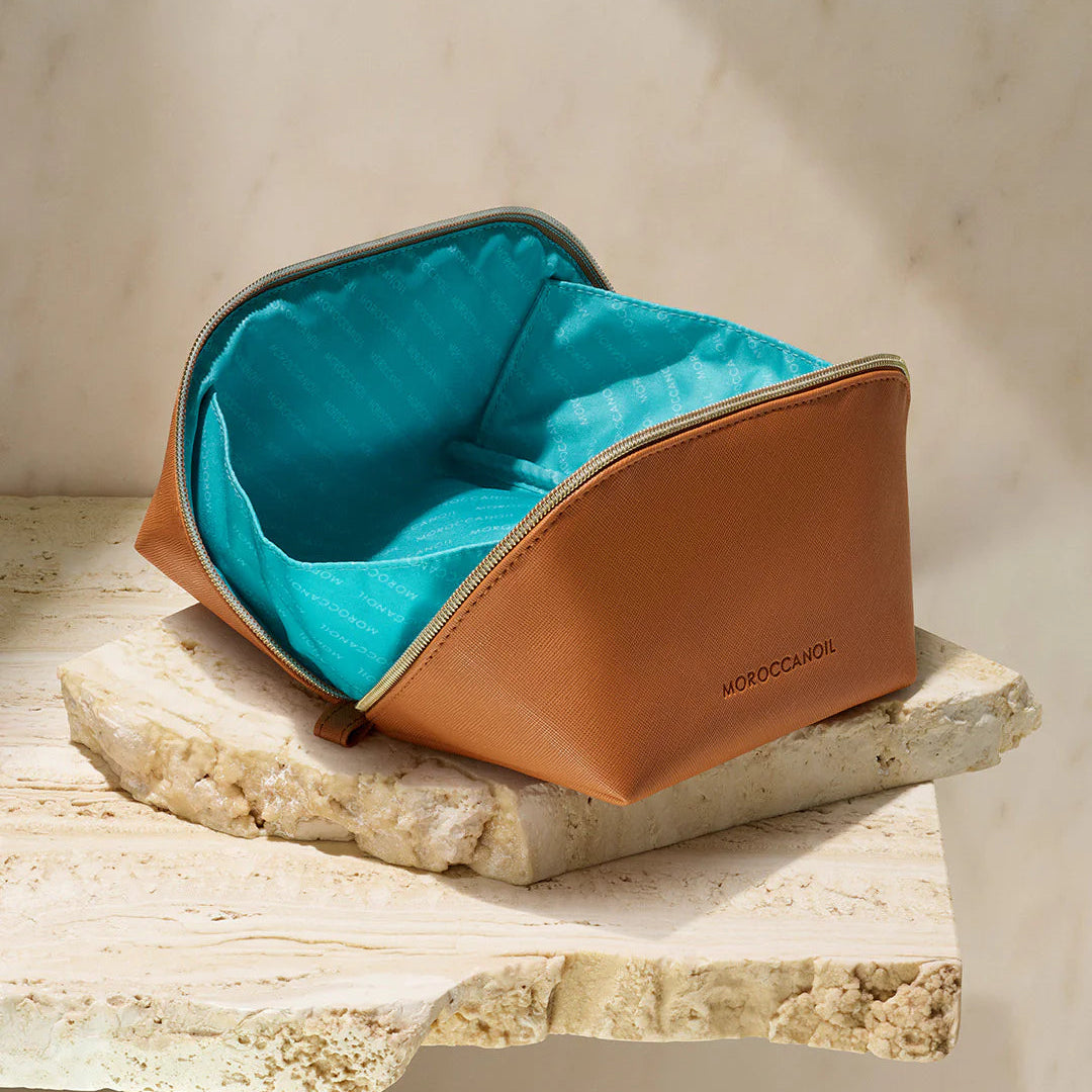 Brown leather case with teal interior on a stone surface