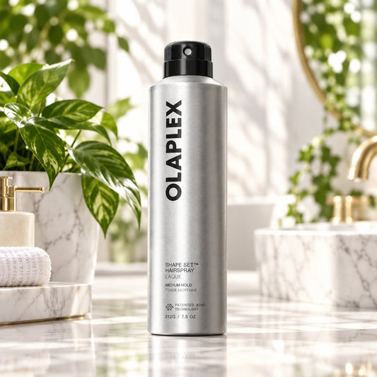 A silver aerosol can of Olaplex Shape Set Hair Spray with a black spray nozzle, shown on a clean white background with a soft shadow.