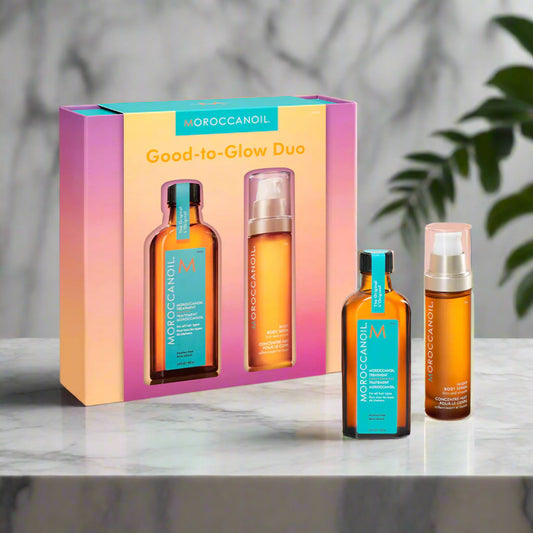 Moroccanoil Good-to-Glow Duo set with two bottles and a box on a gradient background